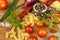 Raw pasta with tomatoes and parsley on a wooden background. Preparation diet food. The recipe for a simple dinner.