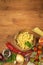 Raw pasta with tomatoes and parsley on a wooden background. Preparation diet food. The recipe for a simple dinner.