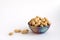 Raw peanuts in shell on clay cup, groundnuts on white background