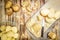 Raw peeled sliced potato, pile of potatoes and knife on rustic wooden table