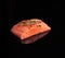 Raw piece of salmon fillet with a sprig of rosemary on a black reflective background