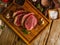 Raw pieces of meat, pork, veal, beef sprinkled with spices on a wooden background. Low angle view. Cooking meat steaks. Restaurant