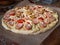 Raw pizza with sausage, cheese and tomatoes prepared for round baking