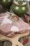 Raw pork ,ceramic pots, rosemary and spices on a wooden board on