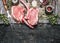 Raw pork chop steaks with meat fork, oil and spices for grill or cooking on rustic metal background, top view,