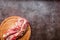 Raw pork on a chopping board on a dark wooden surface. Food background with copy space. Toned