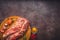 Raw pork on a chopping board on a dark wooden surface and spice for cooking. Food background with copy space. Toned