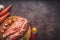 Raw pork on a chopping board on a dark wooden surface and spice for cooking. Food background with copy space. Toned