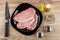 Raw pork cutlets in plate, spices, salt, pepper, vegetable oil