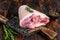 Raw pork Eisbein knuckle ham on a wooden board with meat cleaver. Dark Wooden background. Top view