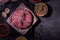 Raw pork hamburger cutlet with spices on a dark background. Home production of semi-finished products