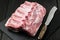 Raw pork loin and knife on slate plate