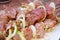 Raw pork meat with onions and spices for cooking kebabs on skewers on the grill.