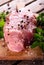 Raw pork meat on wooden board with herbs and salt with pepper