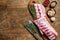 Raw pork rack spare ribs with spices, garlic cloves and thyme. Wooden background. Top view. Copy space