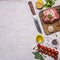 Raw pork steak with spices, garlic and herbs, lemon and butter knife for meat, tomatoes a branch, black pepper, dill, border, w