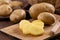 Raw potato sliced on board prepare for cooking, Fresh organic golden potatoes on wooden desk