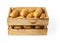 Raw potato tubers in a wooden crate isolated on a white background. Fresh yellow potatoes in a wooden box. Rustic style container