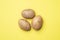 Raw potato tubers on a yellow background