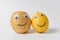 Raw potatoes and lemon with Googly eyes and smile on white background. Food with funny face