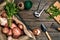 Raw potatoes in a linen bag, arugula, garlic, garden shovel and rake, food background, top view