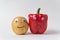 Raw potatoes and red bell pepper with funny faces on white background