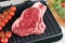 Raw prime steaks on electric grill. Black angus prime meat steaks Ribeye on modern electric grill with rosemary, cherry tomato