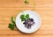 Raw purple speckled kidney beans with bean stem on saucer