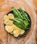 Raw ravioli with fresh spinach leaves in gray plate on wooden background with meal