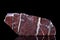 Raw red jasper mineral stone in front of black background