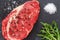 Raw ribeye beef steak with spices, Black Angus meat with seasonings, gray stone background, top view