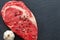 Raw ribeye beef steak with spices, Black Angus meat with seasonings, gray stone background, top view, copy space