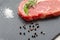 Raw ribeye beef steak with spices, Black Angus meat with seasonings, gray stone background, top view, copy space