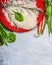 Raw Rice, fresh delicious vegetables and ingredients for cooking on gray wooden background, top view