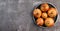 Raw ripe onions bulbs on a round plate on a dark background