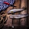 Raw river fish,knife and stripped vest on old wooden table.