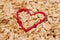 Raw rolled breakfast oats in a red heart shape. Healthy meal