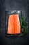 Raw salmon filet on dark slate background, wild atlantic fish, space for text