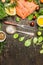 Raw salmon fillet with ingredients for cooking, fork and spoon with salt on rustic wooden background, top view