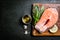 Raw salmon with herbs and spices, rustic background