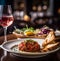 Raw salmon tartare with black caviar and a glass of rose wine on a restaurant table. Fresh salmon starter on a whote plate, fine