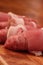 Raw sausages wrapped in bacon on a chopping board