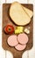 Raw scalded sausage on a wooden board