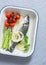 Raw sea bass, cherry tomatoes and asparagus in the baking tray. Ingredients for lunch. On a blue background