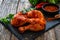 Raw seasoned chicken thighs on stony cutting board on wooden table