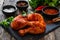 Raw seasoned chicken thighs on stony cutting board on wooden table