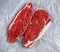 Raw seasoned sirloin prime british steaks on paper