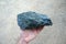 Raw of serpentinite mineral rock in the hand of a geologist.