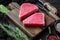 Raw sesame tuna steak ingredients, on wooden cutting board, on black wooden background