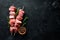 Raw shish kebab. Barbecue Meat Spices and Herbs. On a black stone background.